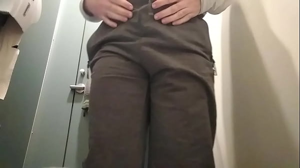 Gay young man peeing in a public toilet